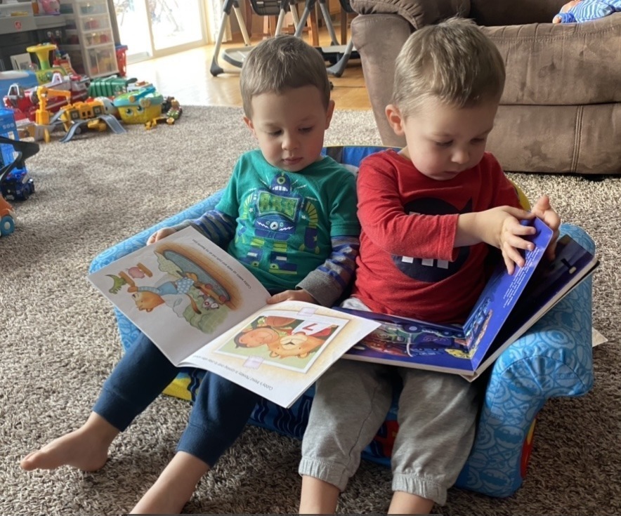my twins on the little couch looking at books together