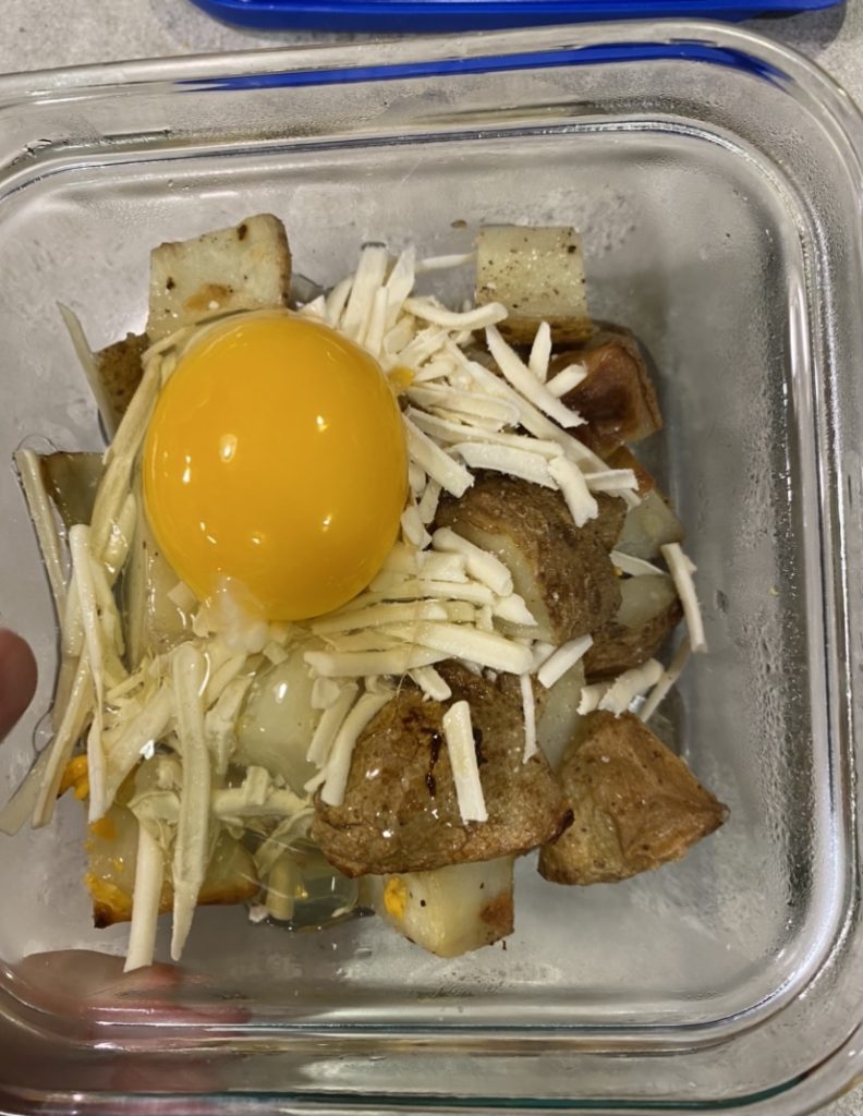 Cracked egg on top of potato dish