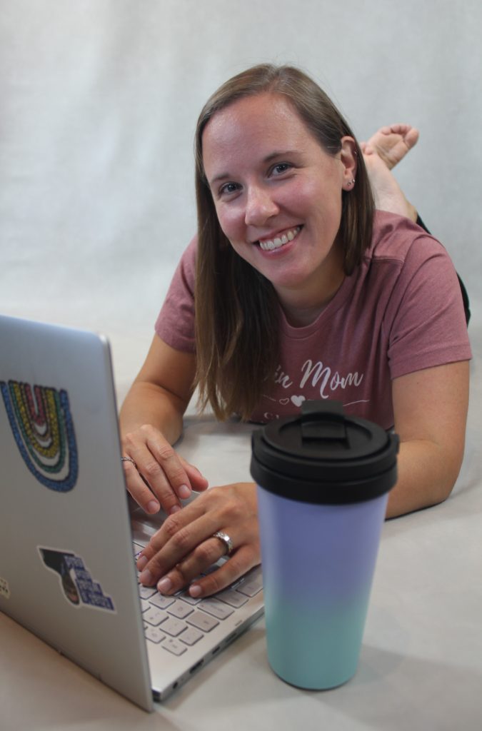 Nicole from The Way it Really Is. Nicole laying on stomach, working on my blog with coffee thermos in the foreground. 