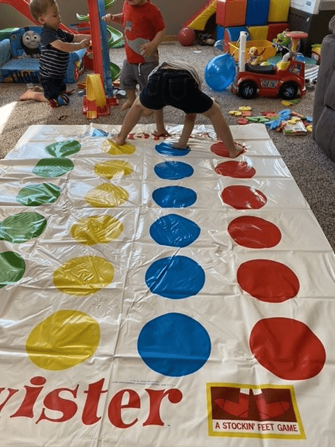 My oldest playing Twister while my younger twins play with cars